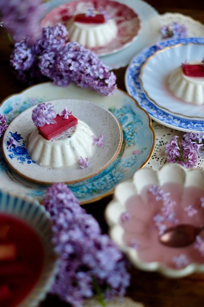 Vanilla bean panna cotta with lilac syrup and poached rhubarb, surrounded by lilacs