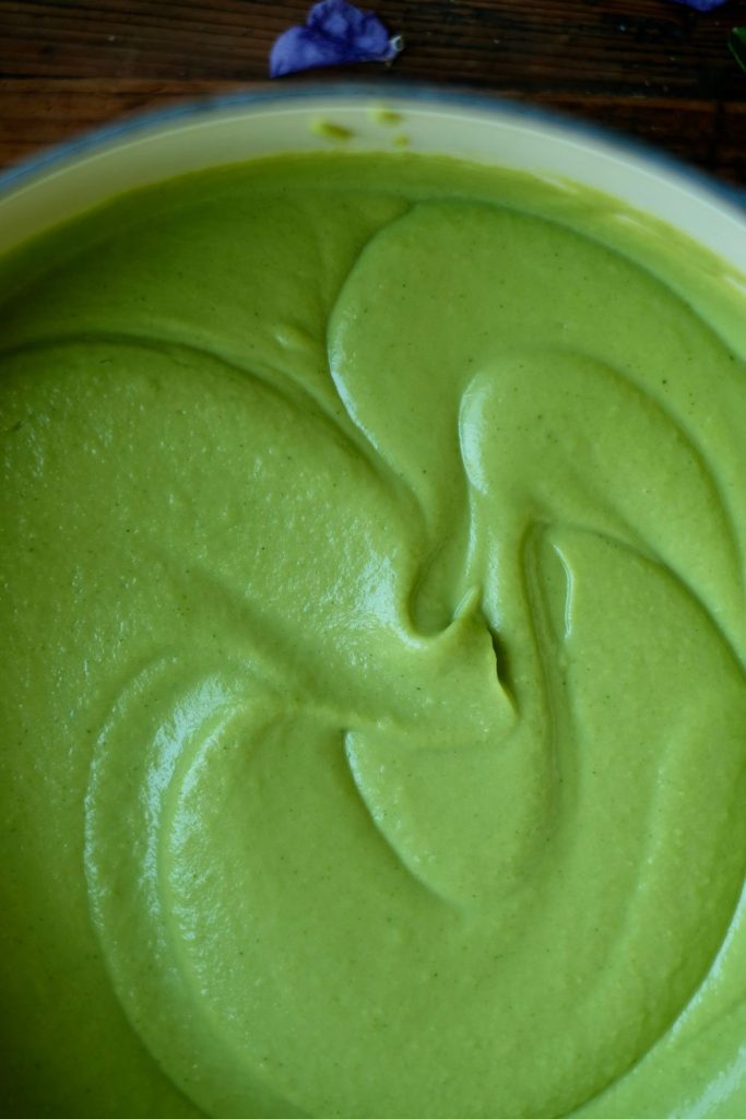 Velvety, thick bright green spring pea soup after blending