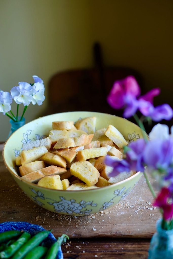 Sliced baguette bread cubes in a bowl with olive oil and butter