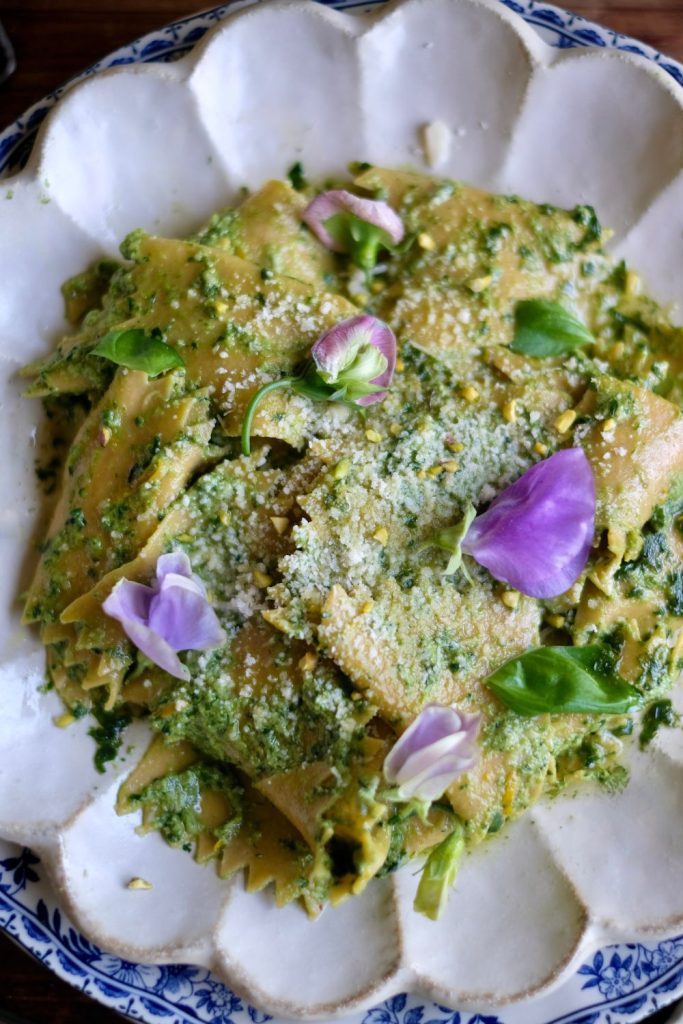 Pesto Fazzoletti Pasta topped with parmesan and edible flowers